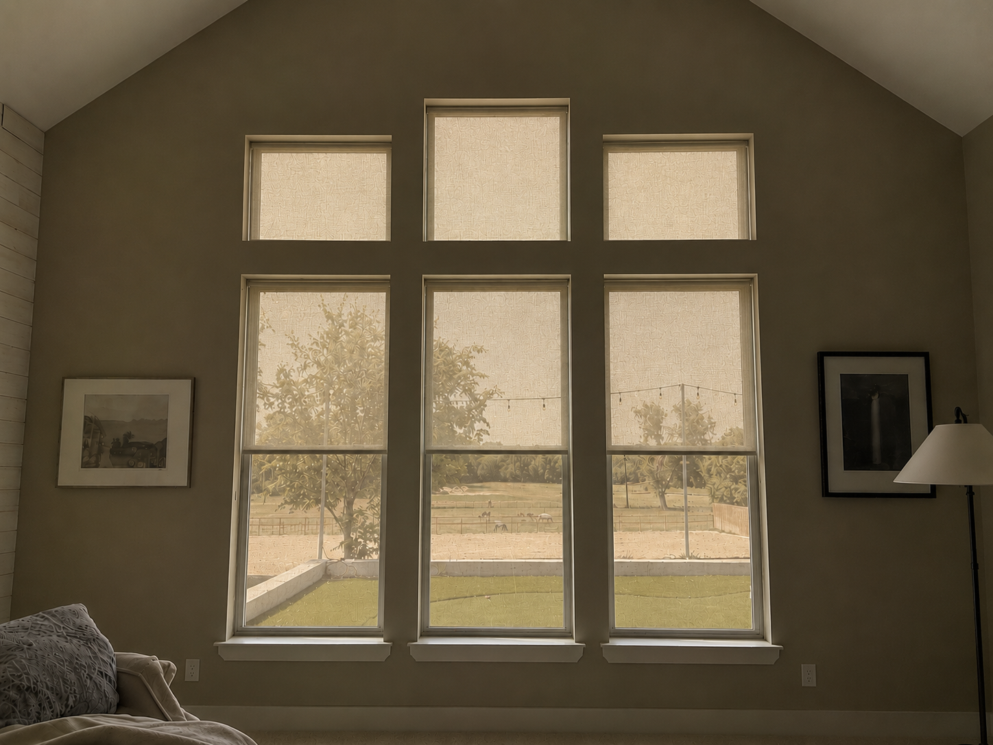 The same bedroom with interior blinds open and exterior screens lowered outside the glass. Daylight enters softly, the view remains visible but filtered.
